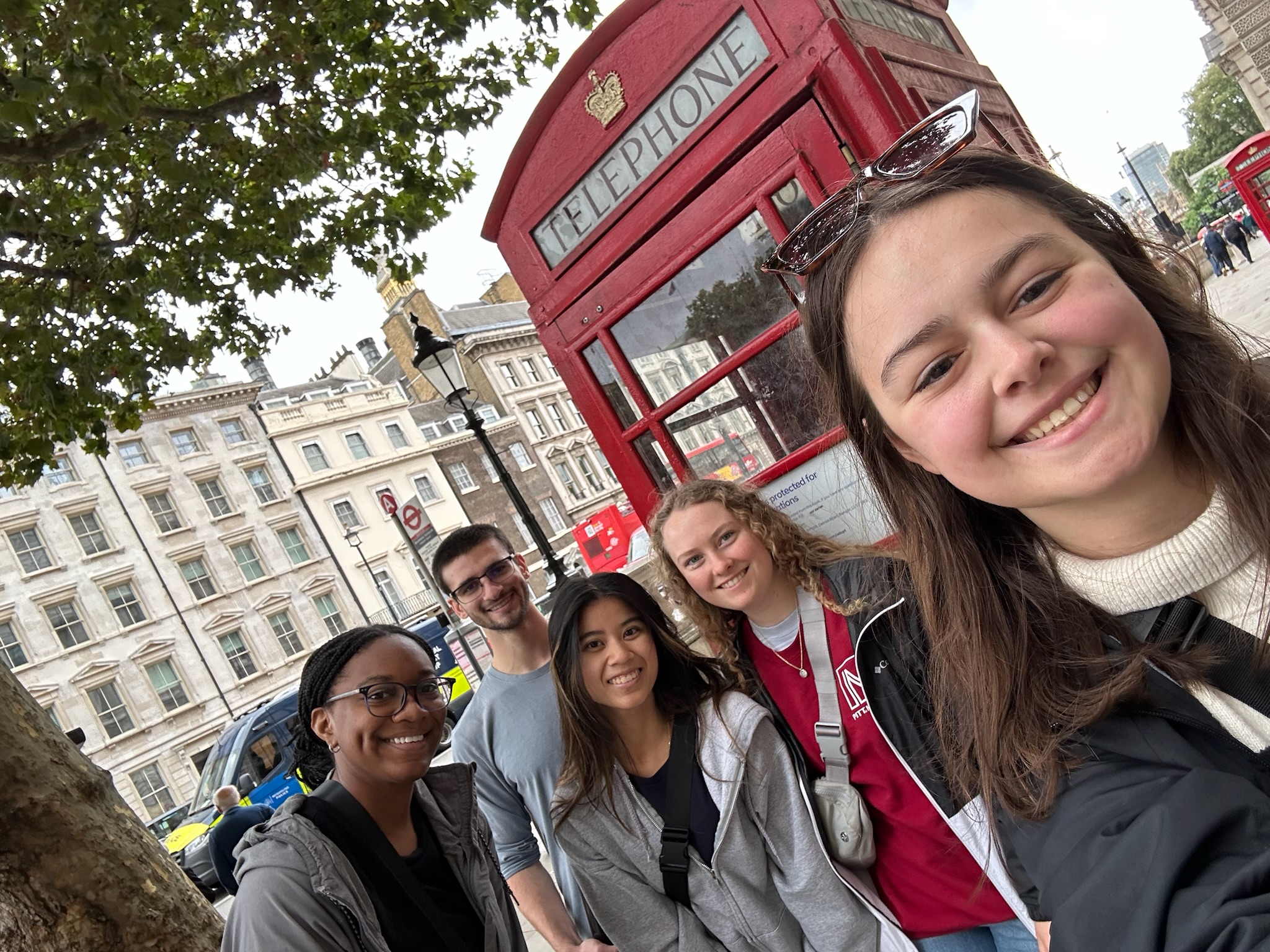 Makerspace students pose in front of a British Red telephone booth