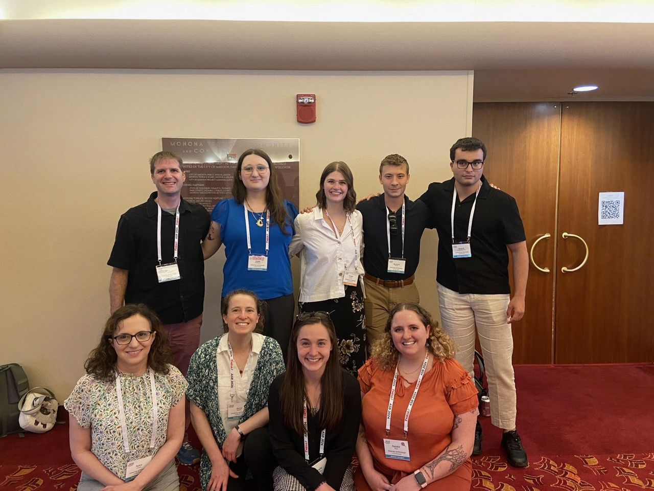 Anna Bailes and her students smile at a conference spotlighting their work