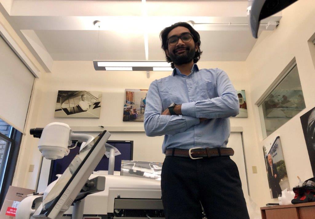 Utkarsh Bhadani standing in front of medical equipment