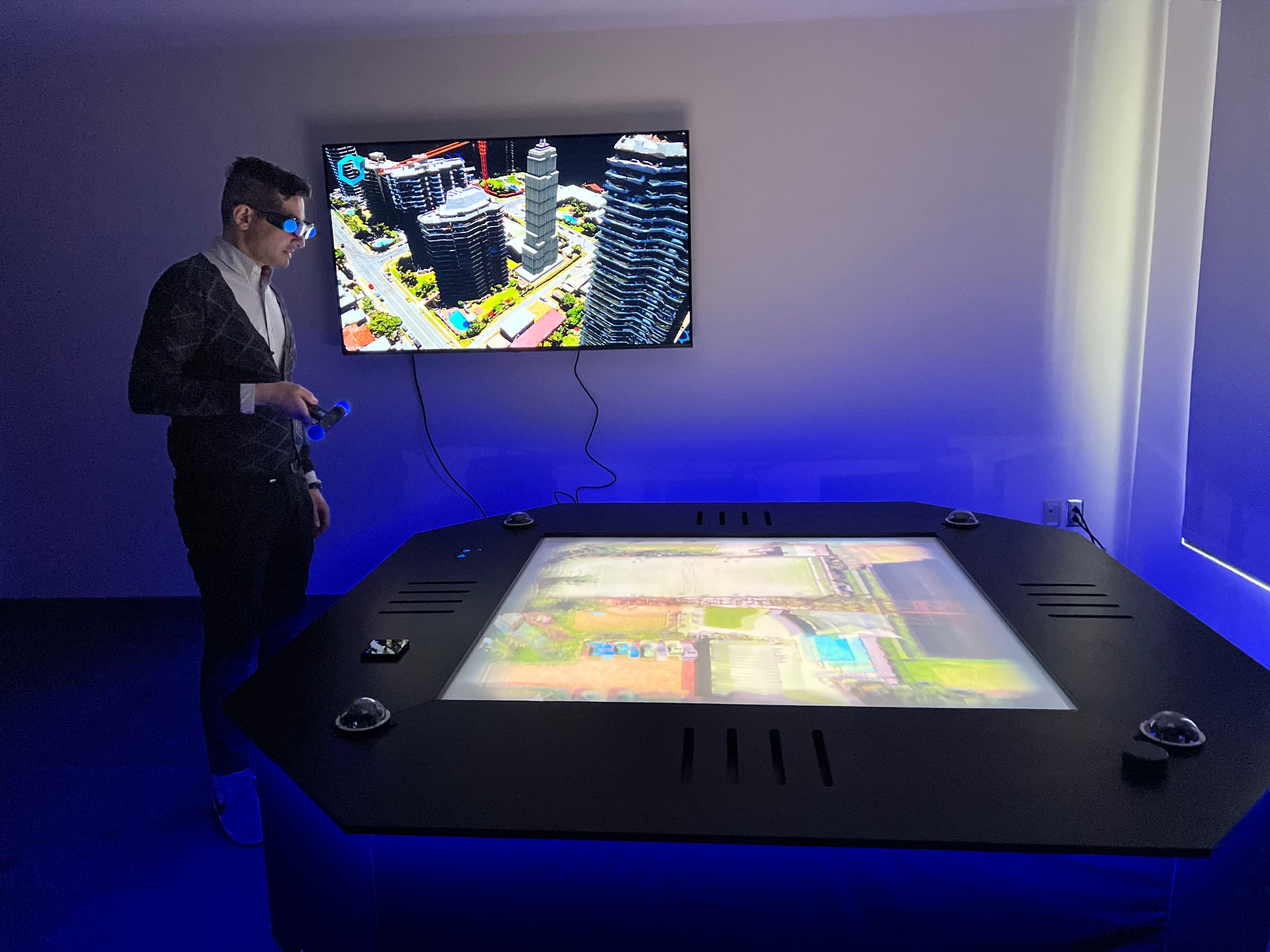 a person using a VR set with a tv in the back showing what they are seeing