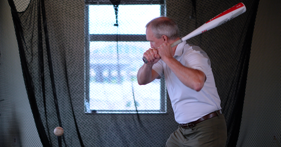 Man with baseball bat hitting a ball