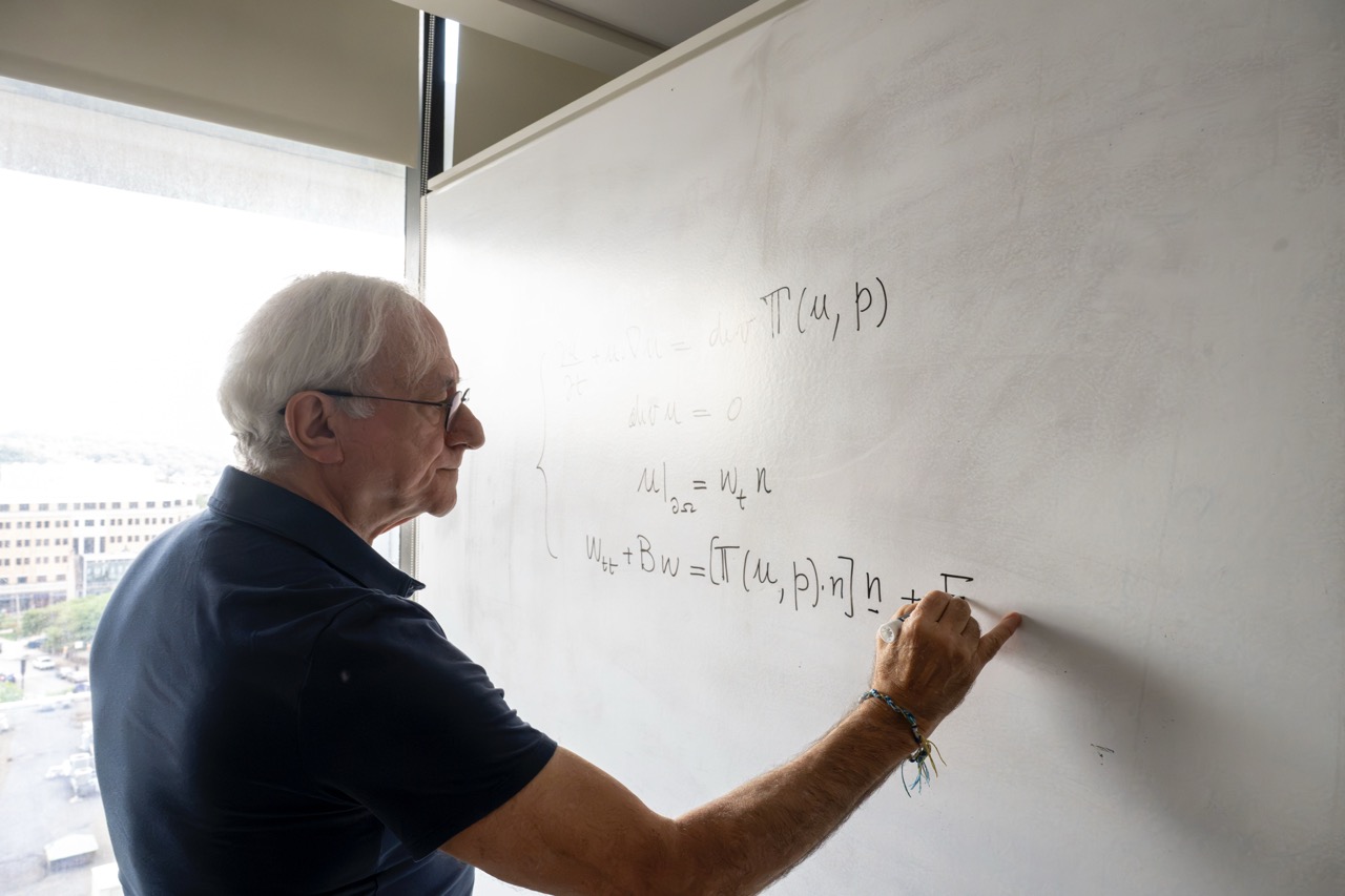 G. Paolo Galdi writing an equation on a whiteboard