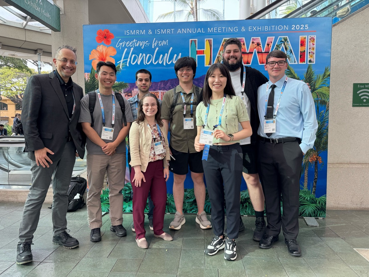a poster presentation group in front of the exhibition sign in honolulu, 2025