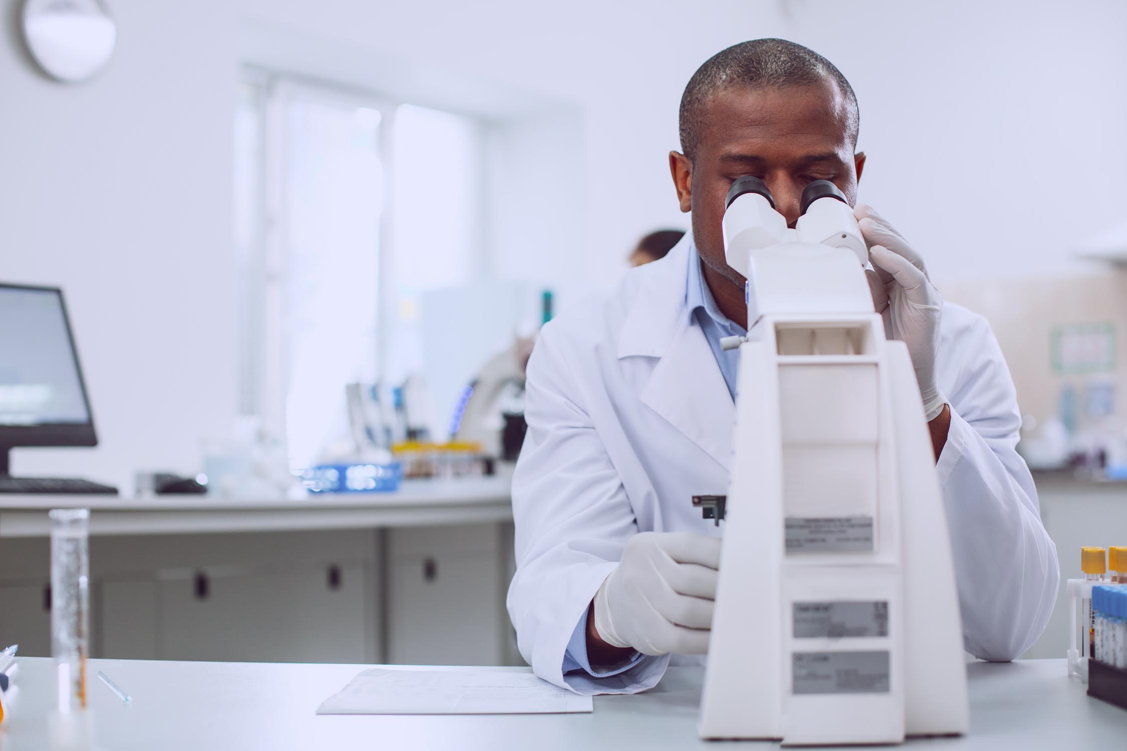 A man in a lab with a microscope