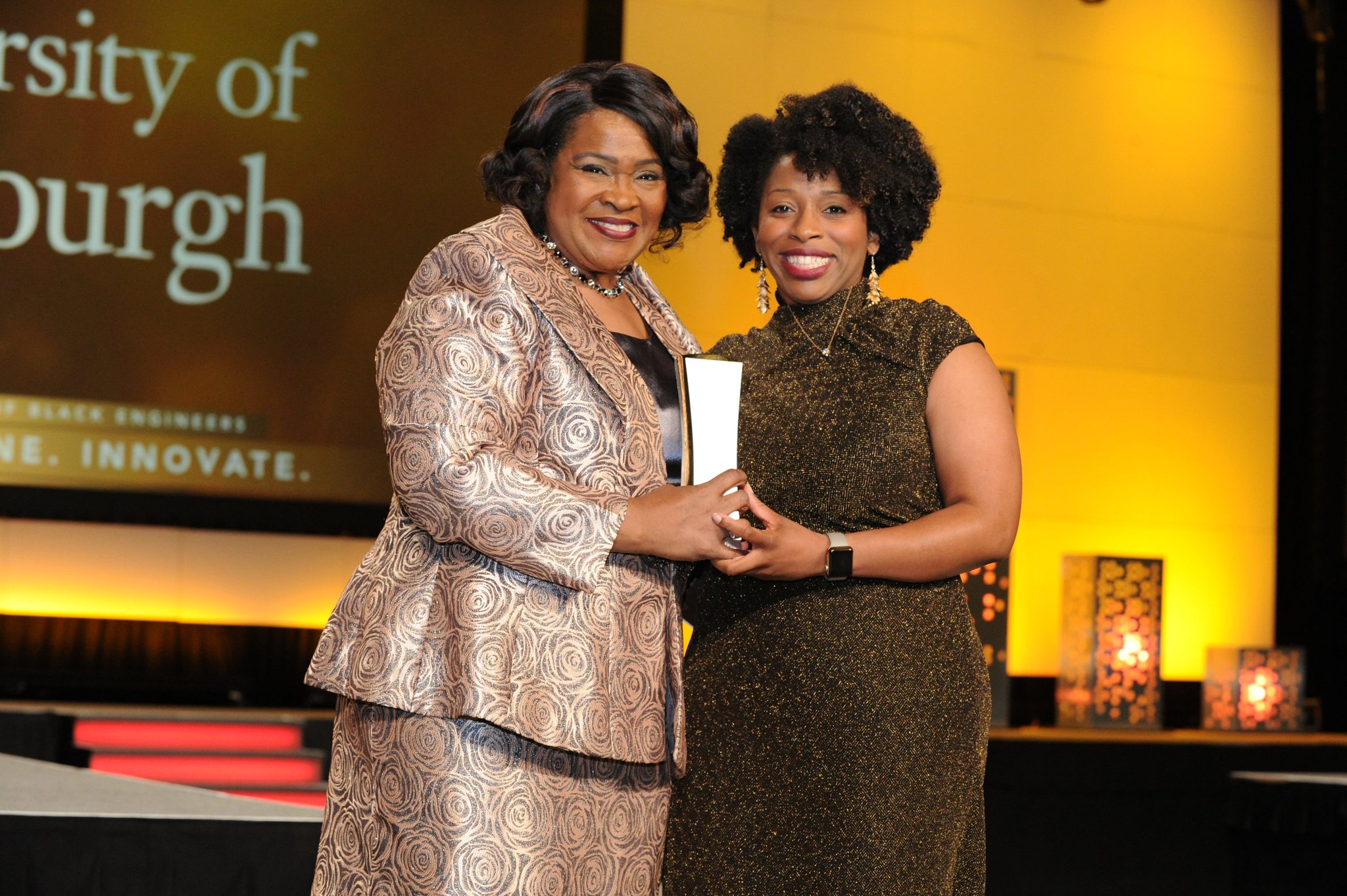 Two people on stage at an awards presentation