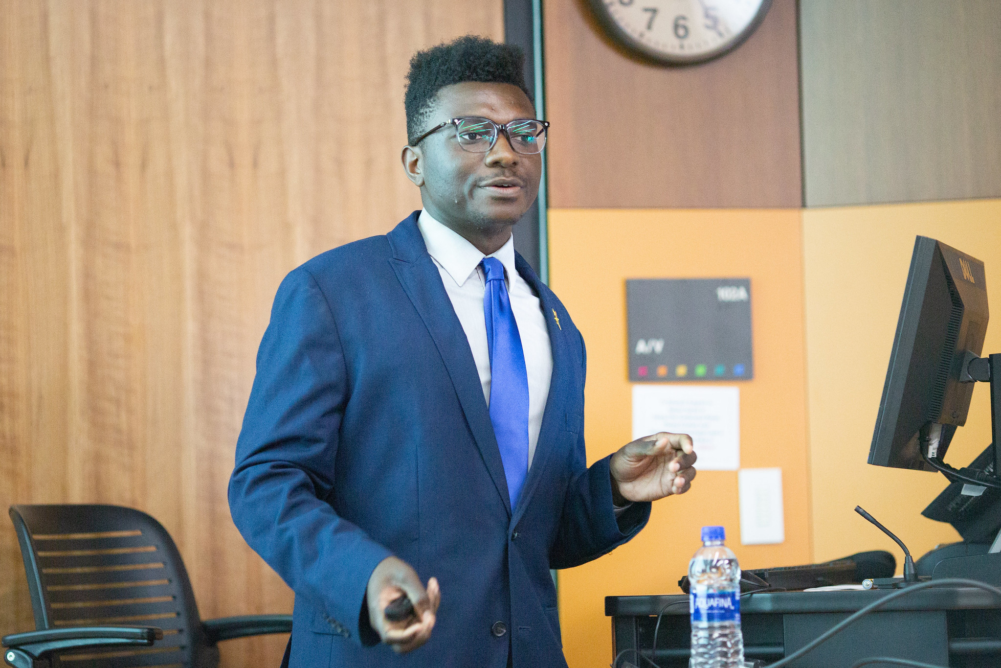 A person in a suit talking in front of a classroom