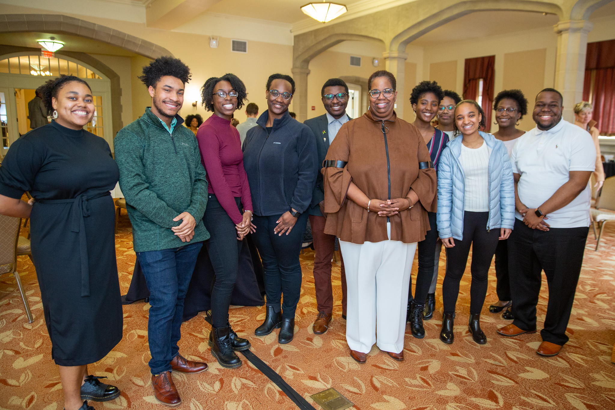 A group of people standing in a line smiling