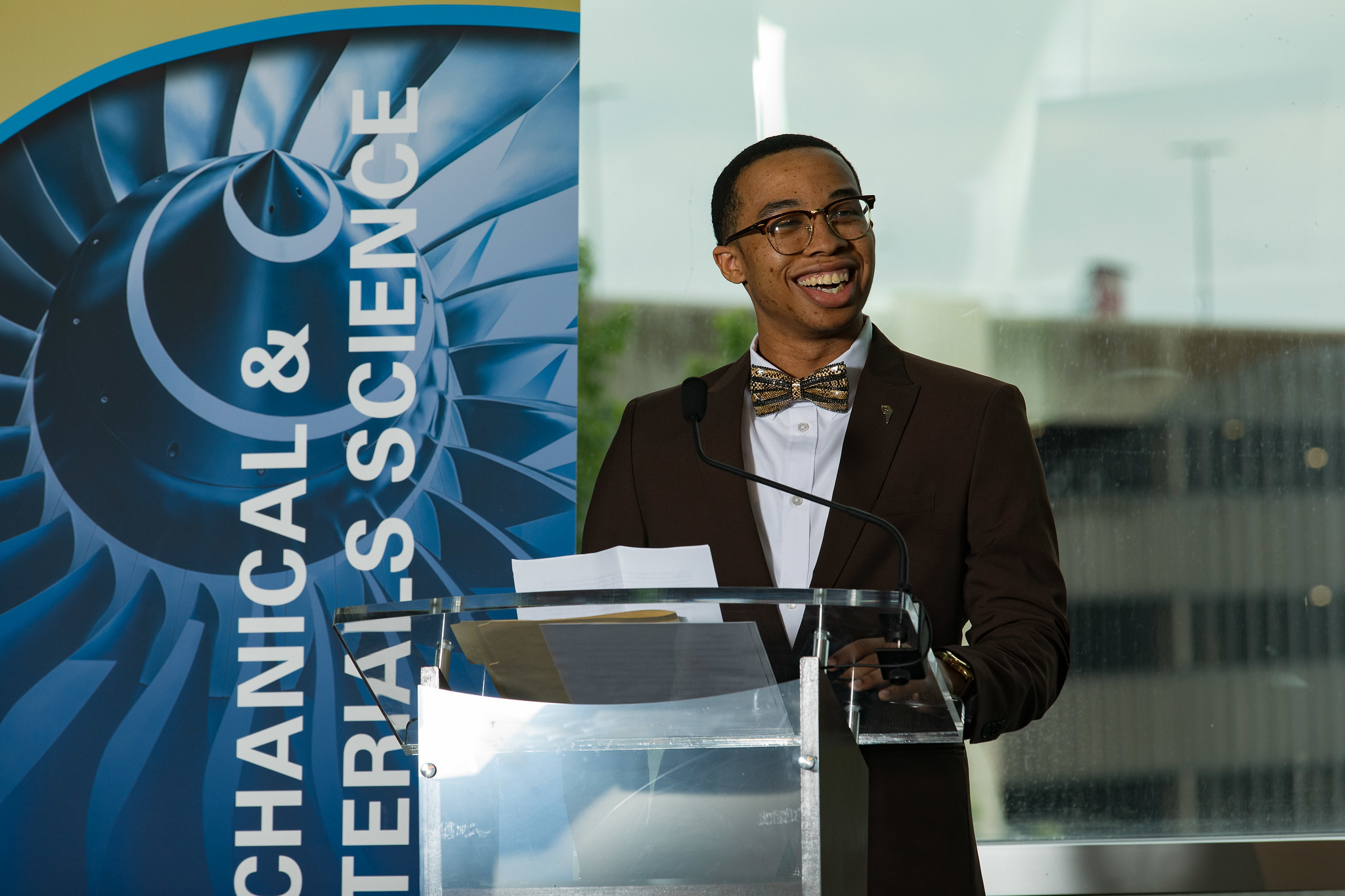 A person in a suit talking in front of a podium