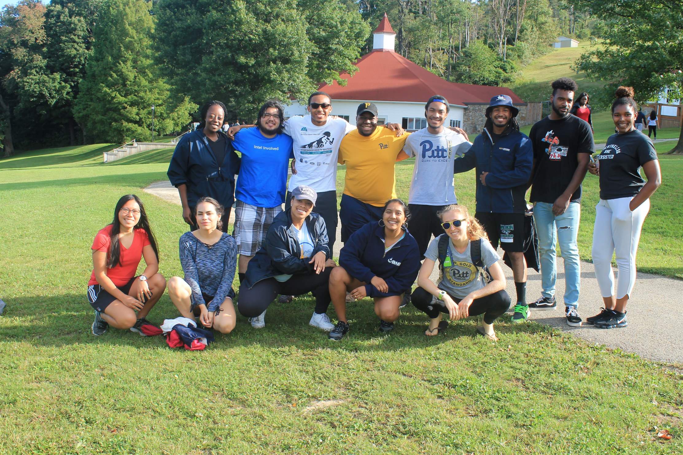 A group of students outside smiling on a sunny day