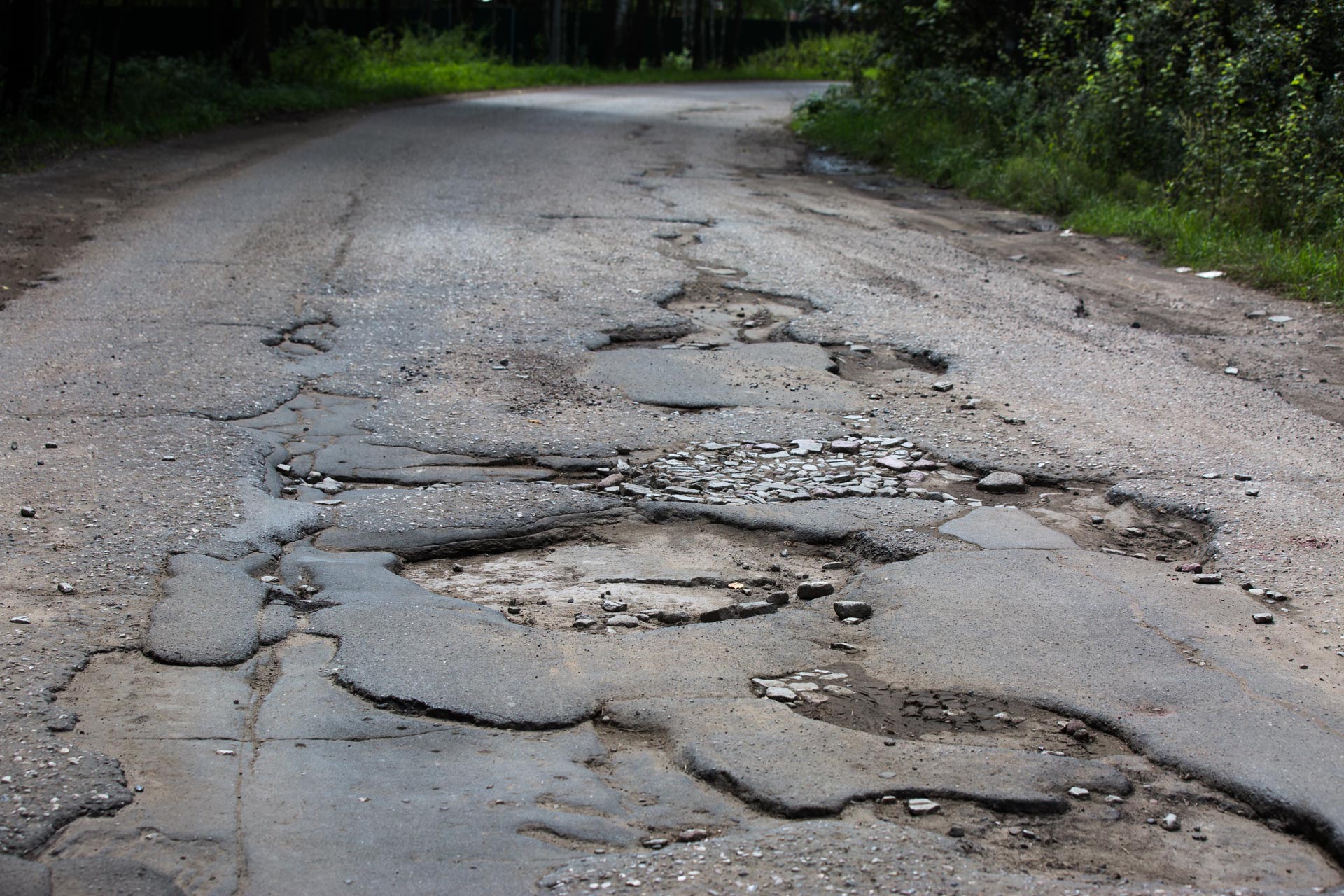 A road with many potholes and patches